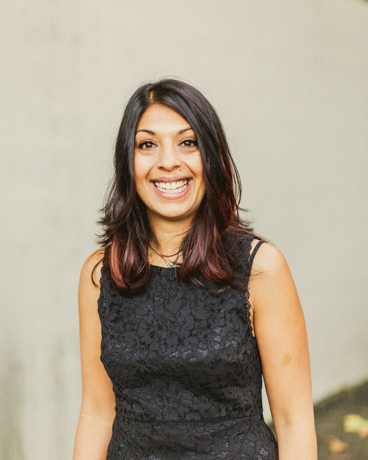 Jamila at 39, smiling, in a black lace dress